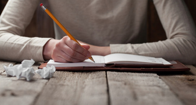 hand writes with a pen in a notebook